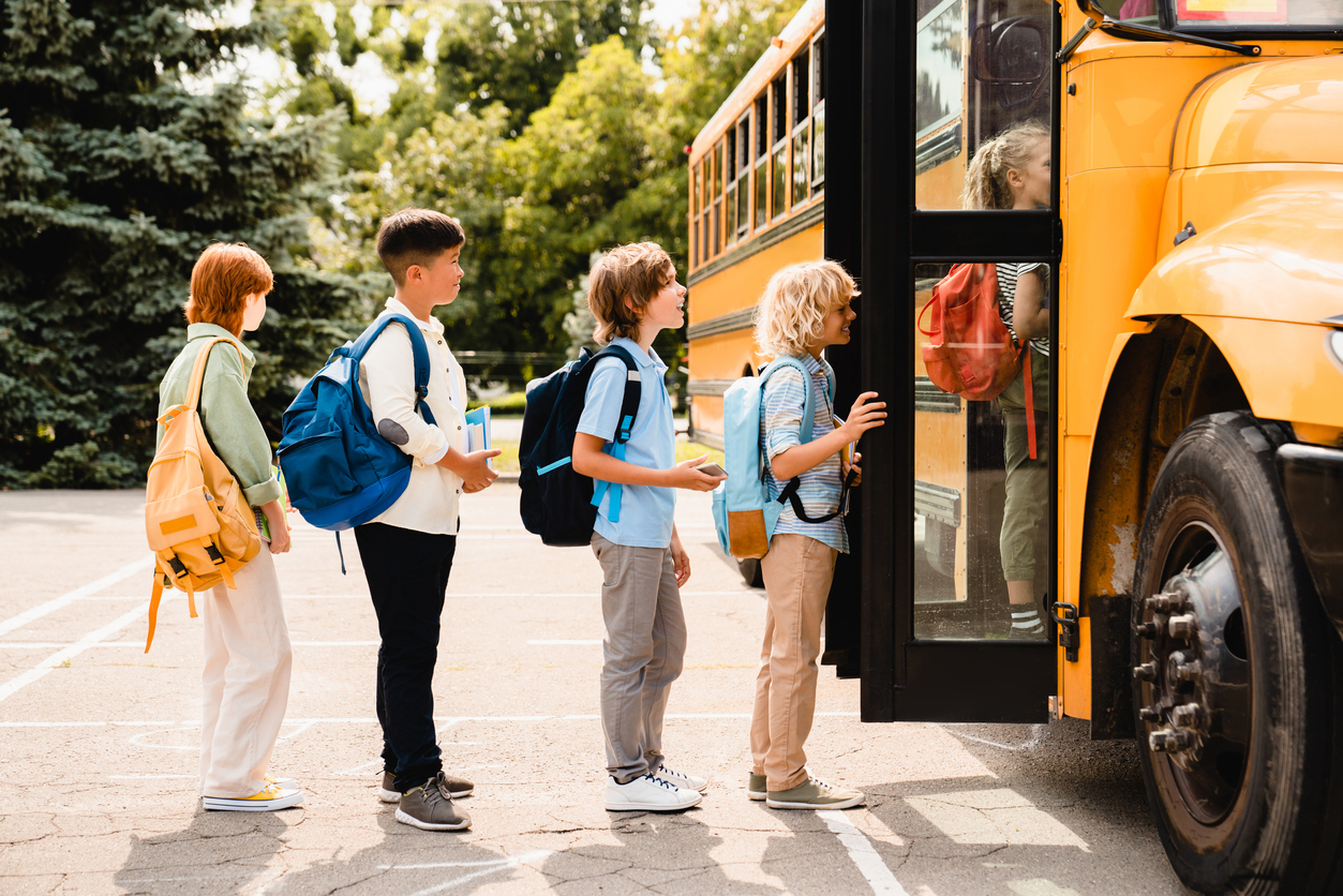Elementary school students lining up to get on the bus for the first day of school